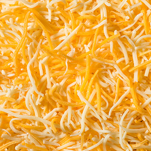 Image of shredded yellow and white cheese.